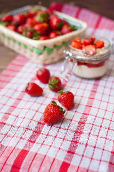 Fresh strawberries on the tablecloth and in the basket — Stock Photo, Image