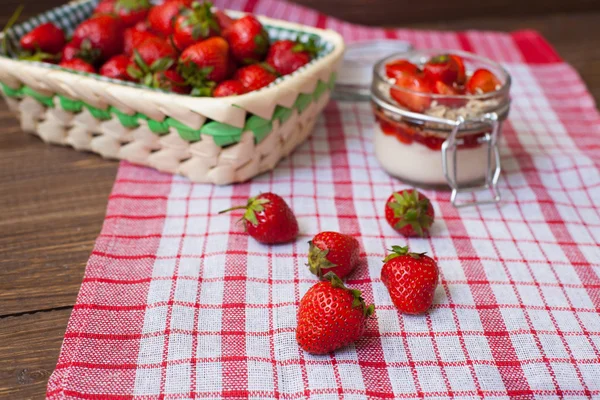 Fresh strawberries on the tablecloth and in the basket — Stock Photo, Image