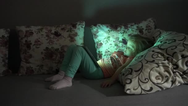 Menina deitada no sofá e assistindo desenhos animados — Vídeo de Stock