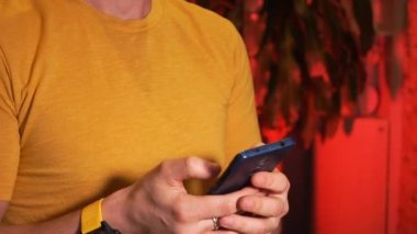 Akıllı telefon kullanan bir adam çevrimiçi mesajlaşıyor ya da geziniyor