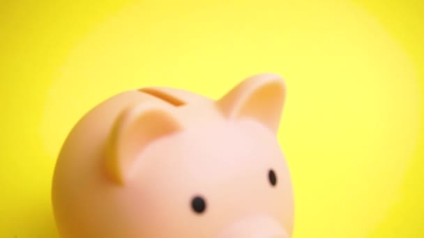 Caja de dinero rosa banco en fondo amarillo — Vídeos de Stock