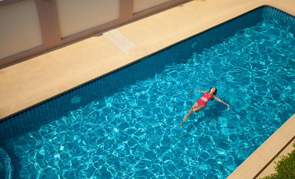 Женщина плавает и отдыхает в бассейне — стоковое фото