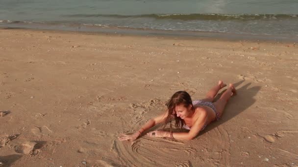 Woman on the beach drawing on sand — Stock Video