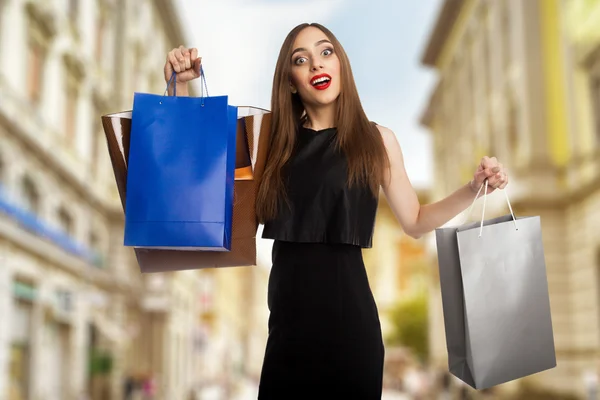 Joven modelo al aire libre llevando bolsas — Foto de Stock