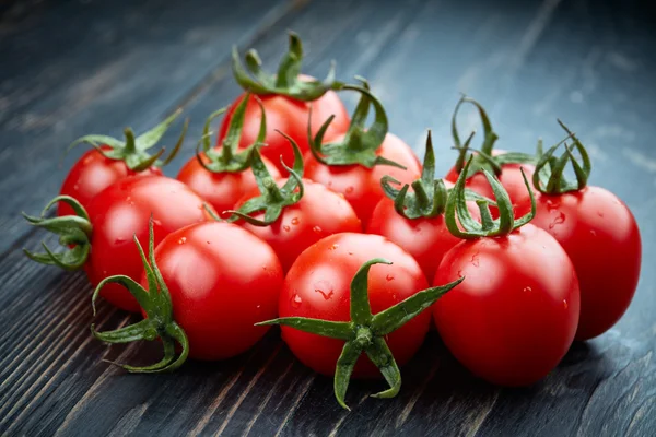 Rijpe tomaten op donkere houten achtergrond — Stockfoto