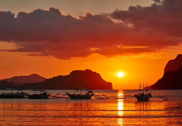 Barcos filippino tradicionales en la bahía de El Nido con luces de puesta de sol. Amigo. —  Fotos de Stock