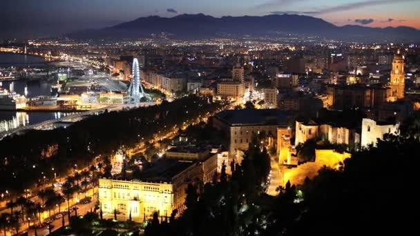 Malaga stadsgezicht na zonsondergang, Spanje. Kathedraal, stadhuis Alcazaba citadel en haven. Panning shot — Stockvideo