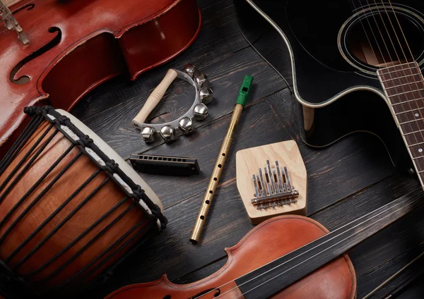 Set muziekinstrumenten op donkere houten achtergrond: gitaar, vi — Stockfoto