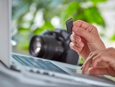 Kadın onu laptop için fotoğraf makinesinden fotoğrafları kopyalama.