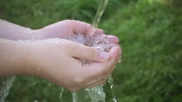 Flux d'eau propre se déversant dans les mains des enfants — Video