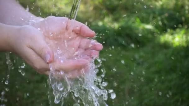 Mani di donna con spruzzi d'acqua. Colpo al rallentatore — Video Stock