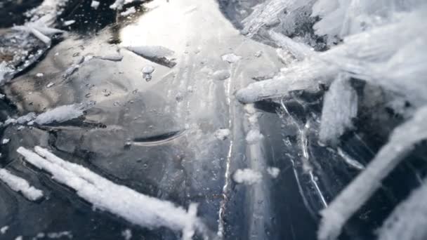 A kamera lassan mozog a befagyott folyó jeges felszínén. Téli fagyos víz táj. A fák és az ég tükröződik a jég tükrében. Csúszó lövés, 4K — Stock videók