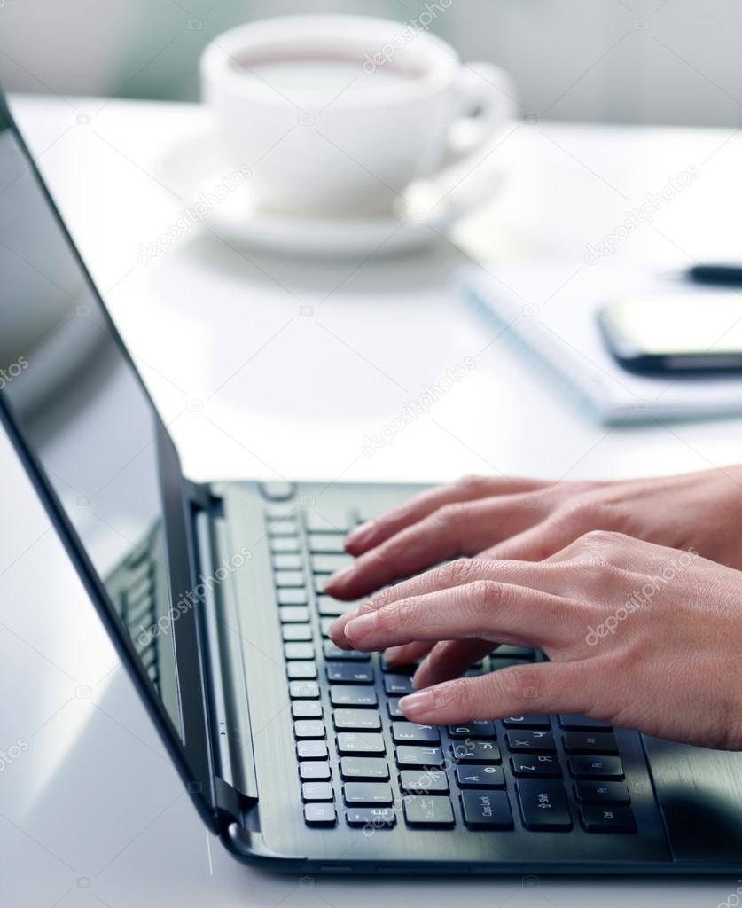 Woman hands typing on laptop