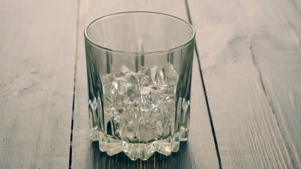 Наливаємо шотландське віскі в склянку з льодом — стокове відео