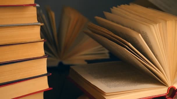 Old books on wooden deck table and dark background — Stock Video