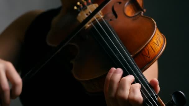Mujer tocando violín sobre fondo oscuro . — Vídeos de Stock