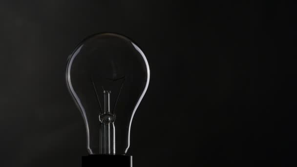 Light bulb over black background. — Stock Video