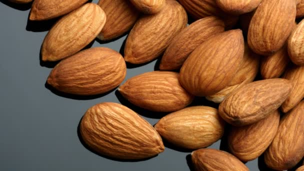 Almonds over black background — Stock Video