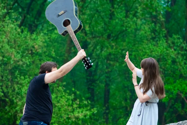 Mężczyzna Uderzający Kobietę Gitarze Outdoor Zwalczanie Przemocy Wobec Kobiet — Zdjęcie stockowe