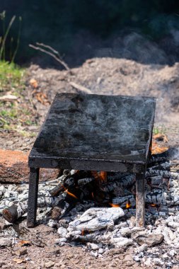 Boş taş ızgara tabağı, odun ve dumanla ısıtılıp atmosfere gidiyor. Doğada barbekü.