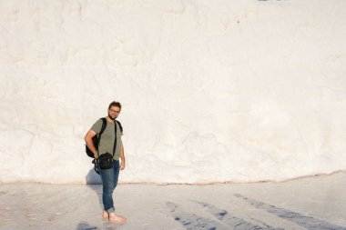 Mutlu turist çıplak ayakla Pamukkale 'de havuzda yürüyordu.