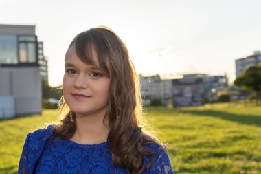 Açık havada poz veren sevimli bir genç kız. Şık mavi gece elbisesi içinde güzel bir kadın model.