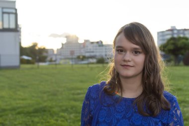 Açık havada poz veren sevimli bir genç kız. Şık mavi gece elbisesi içinde güzel bir kadın model.