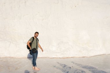 Mutlu turist çıplak ayakla Pamukkale 'de havuzda yürüyordu.