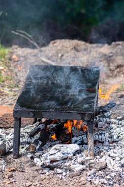 Boş taş ızgara tabağı, odun ve dumanla ısıtılıp atmosfere gidiyor. Doğada barbekü.