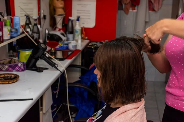 Professionell kvinnlig frisör klippa flickor hår i salong — Stockfoto