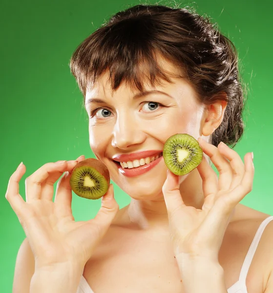 Giovane donna sorridente che tiene kiwi . — Foto Stock