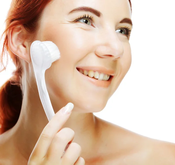 Girl cleaning face with peeling brush — Stock Photo, Image