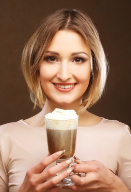 Kahve fincanı tutan genç bir kadın.