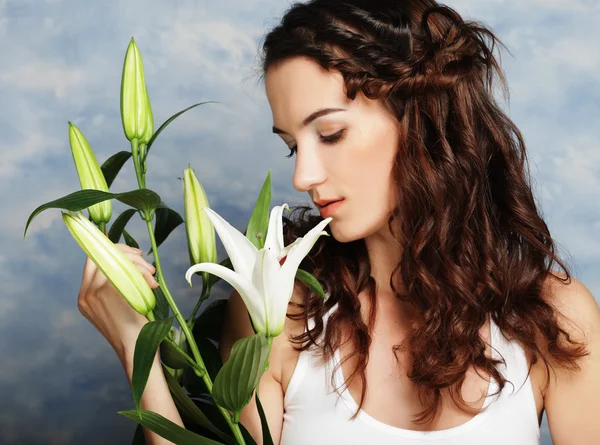 Beauty face of the young woman with pink lily — Stock Photo, Image