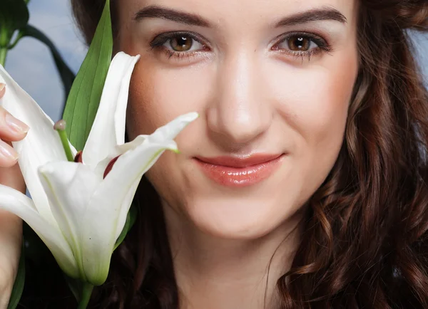 Beauty face of the young woman with pink lily — Stock Photo, Image