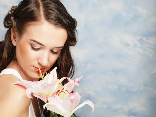Skönhet ansikte av den unga kvinnan med rosa lilja — Stockfoto