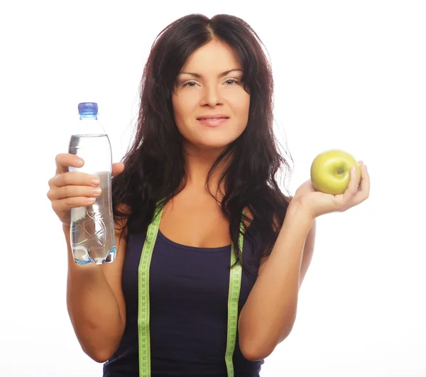 水のボトルと青リンゴを保持する女性フィットネス モデル — ストック写真