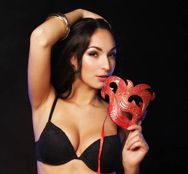 Mujer joven con máscara roja sobre fondo oscuro —  Fotos de Stock