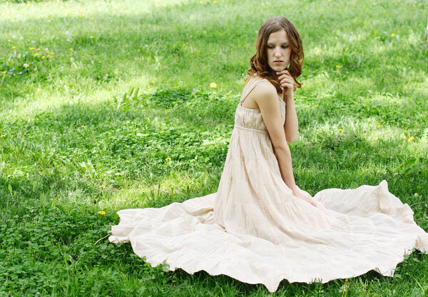 Young redhair woman wearing summer dress in park, happy summer day