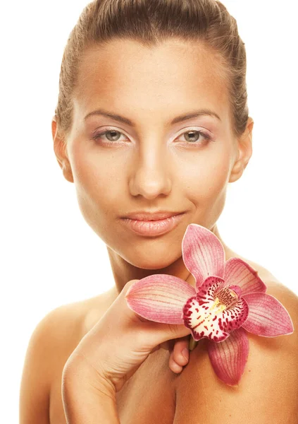 Joven mujer bonita con orquídea rosa, aislada sobre fondo blanco Fotos De Stock