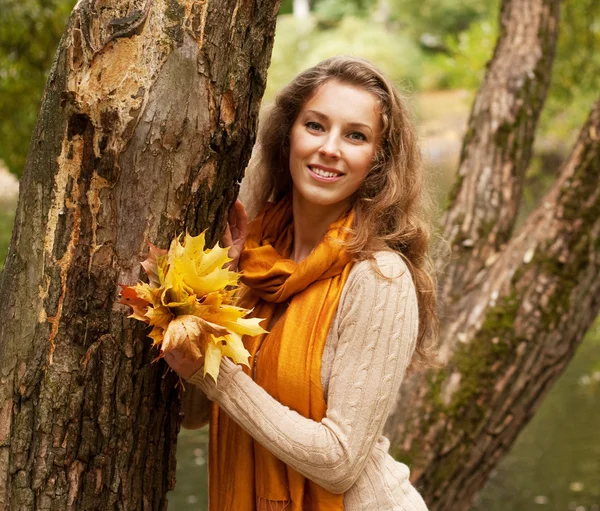 Mladá usměvavá žena v podzimním parku — Stock fotografie