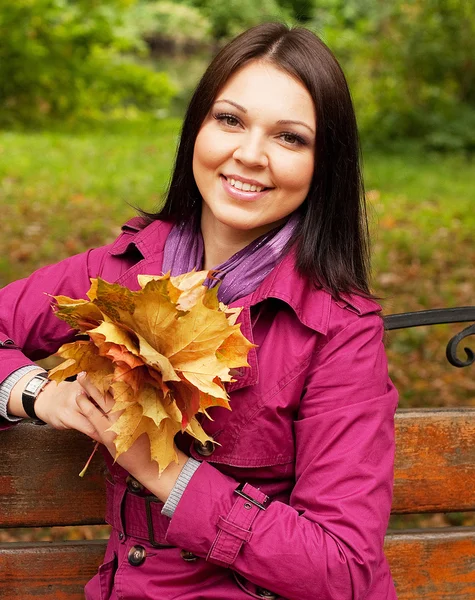 Giovane donna elegante con foglie d'autunno — Foto Stock