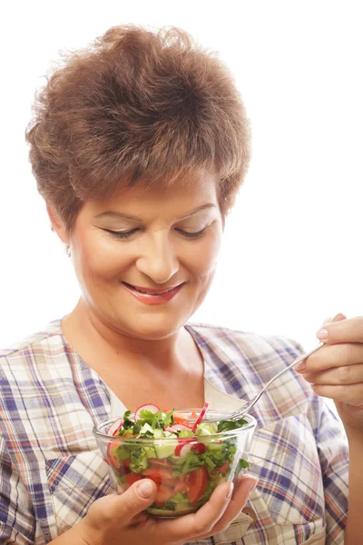 Érett mosolygó nő eszik saláta — Stock Fotó