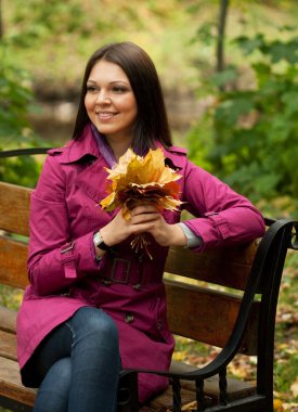 Sonbahar yaprakları olan zarif bir kadın.