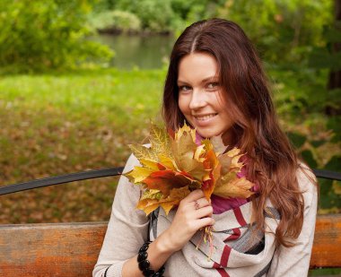 Sonbahar yaprakları olan zarif bir kadın.