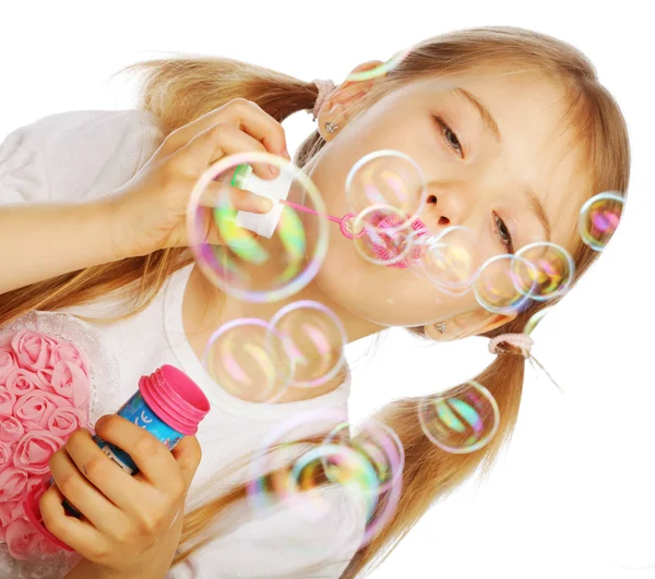 Funny lovely little girl blowing soap bubbles — Stock Photo, Image