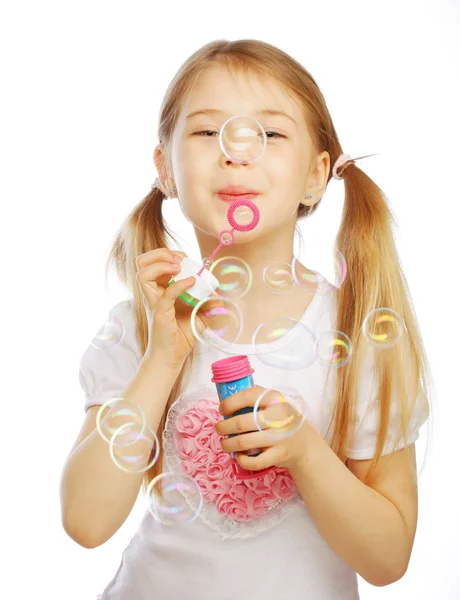 Funny lovely little girl blowing soap bubbles — Stock Photo, Image