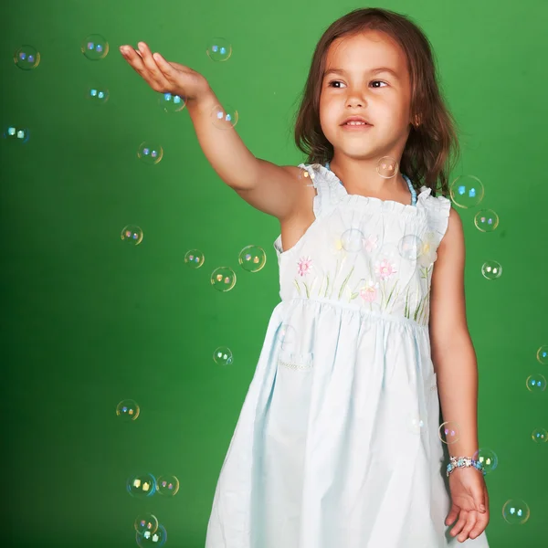 Funny lovely little girl blowing soap bubbles — Stock Photo, Image