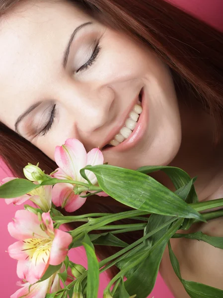 Jonge mooie vrouw met roze bloemen — Stockfoto