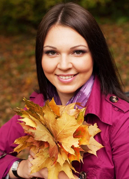 Giovane donna elegante con foglie d'autunno — Foto Stock